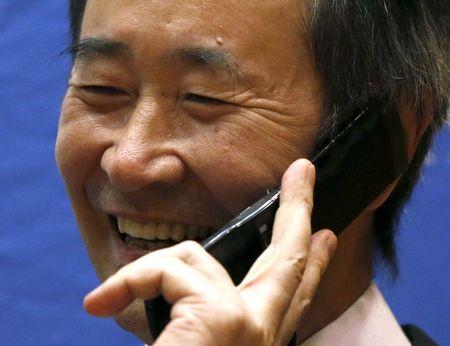 Takaaki Kajita, director of the Institute for Cosmic Ray Research and professor at University of Tokyo, smiles as he speaks with Japanese Prime Minister Shinzo Abe at the start of a news conference in Tokyo October 6, 2015. REUTERS/Issei Kato