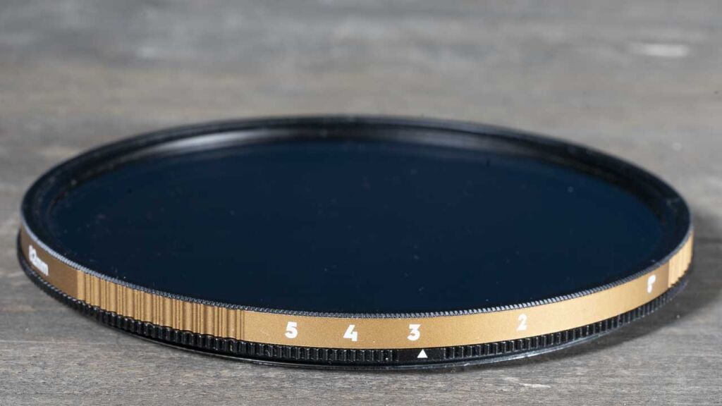 Close-up of a variable ND filter showing the rotating outer ring and the gradient of light attenuation.
